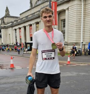 Man standing with a medal following a marathon